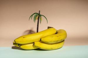 giallo banane e un' palma albero figurina su un' rosa e turchese sfondo, minimalismo, salutare cibo, mare vacanze foto