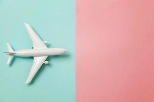 semplicemente piatto posare design miniatura giocattolo modello aereo su blu e rosa pastello colorato carta di moda geometrico sfondo. viaggio di aereo vacanza estate fine settimana mare avventura viaggio concetto. foto