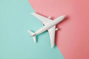 semplicemente piatto posare design miniatura giocattolo modello aereo su blu e rosa pastello colorato carta di moda geometrico sfondo. viaggio di aereo vacanza estate fine settimana mare avventura viaggio concetto. foto