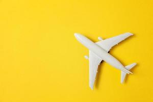 semplicemente piatto posare design miniatura giocattolo modello aereo su giallo colorato carta di moda sfondo. viaggio di aereo vacanza estate fine settimana mare avventura viaggio viaggio biglietto giro concetto. foto