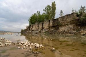 un' fangoso fiume con verde vegetazione su il riva foto