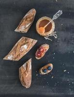 baguette francese tagliata a pezzi, panini con uva rossa foto