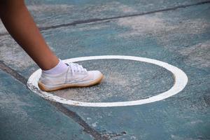 giovane sud-est asiatico femmina sepak takraw giocatore passo sua sinistra piede nel il servendo centro la zona di il Tribunale, all'aperto sepak takraw giocando dopo scuola, morbido e selettivo messa a fuoco. foto