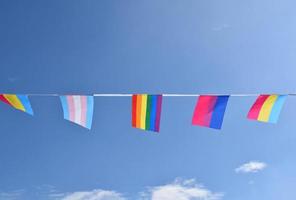 LGBTQ bandiere erano sospeso su filo contro cielo blu su soleggiato giorno, morbido e selettivo messa a fuoco, concetto per LGBTQ Genere celebrazioni nel orgoglio mese in giro il mondo. foto