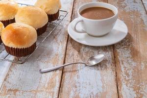 cupcakes freschi e caffè sulla tavola di legno foto