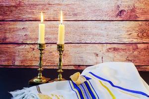 immagine del sabato. pane challah e candele su tavola di legno foto