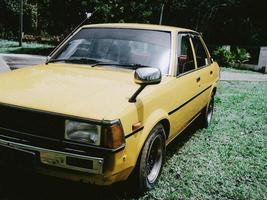 un' classico giallo giapponese auto su il Casa davanti cortile foto