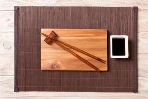 vuoto rettangolare di legno piatto per Sushi con salsa e bastoncini su di legno tavolo, superiore Visualizza foto