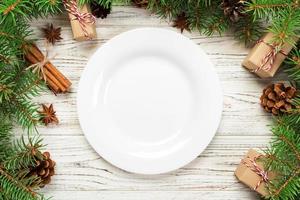 superiore Visualizza. vuoto piatto il giro ceramica su di legno Natale sfondo. vacanza cena piatto concetto con nuovo anno arredamento foto