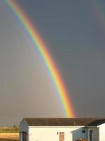 arcobaleno ad arco sopra una casa bianca foto