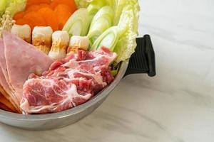 zuppa nera di sukiyaki o shabu con carne cruda e verdure foto