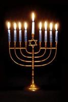 hanukkah menorah brillantemente illuminato su un' nero sfondo foto