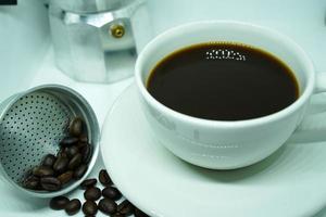 caldo nero caffè nel un' bianca tazza, caffè è un' popolare bevanda tutti al di sopra di il mondo. foto