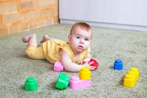 Candido stile di vita ritratto di poco ragazza. bambino giocando con morbido plastica colorato costruttore. foto