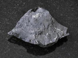 crudo shungite roccia scistosa pietra su buio sfondo foto