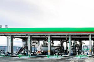 grande verde industriale gas stazione per rifornimento carburante veicoli, camion e carri armati con carburante, benzina e diesel nel il inverno foto