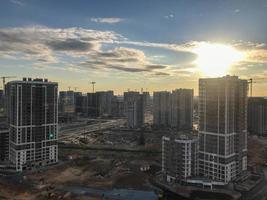 un' nuovo Quartiere nel il città. tiro a partire dal un' altezza. urbano urbano paesaggio. alto bicchiere multipiano edifici di diverso colori e diverso altezza. contro il sfondo di il sole foto