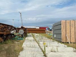 un' grande all'aperto magazzino a un' costruzione luogo, un' magazzino per industriale attrezzatura e materiale nel scatole a un aria aperta Conservazione luogo foto