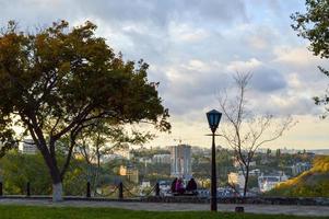 persone riposo nel il parco su il sfondo di il città foto