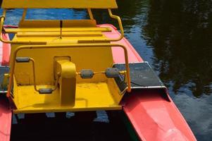 bellissimo ferro rosso acqua catamarano barca con pedali per andare in barca su il lago fiume per il mare su vacanza ricorrere su il molo foto