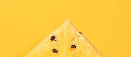 un pezzo di anguria gialla con semi su sfondo giallo, deliziosa frutta rinfrescante foto