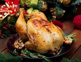 al forno tacchino o pollo. il Natale tavolo è servito con un' tacchino, decorato con luminosa orpello e candele. fritte pollo, tavolo. Natale cena. foto