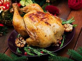 al forno tacchino o pollo. il Natale tavolo è servito con un' tacchino, decorato con luminosa orpello e candele. fritte pollo, tavolo. Natale cena. foto