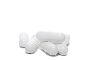 pillole bianche un flacone di pillole su sfondo bianco foto