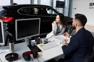 auto concessionaria manager consiglia giovane donna a partire dal acquisto nuovo macchina, il concetto di acquisto un' auto su contratto di locazione foto
