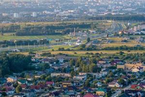 aereo panoramico Visualizza di verde villaggio con famiglie, case, fienili e ghiaia strada nel foresta foto