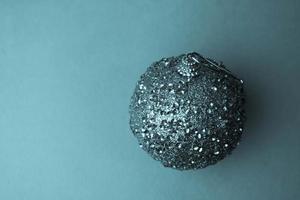 piccolo il giro bicchiere plastica inverno elegante brillante decorativo bellissimo natale festivo Natale sfera, Natale giocattolo intonacato al di sopra di scintille su un' blu sfondo foto