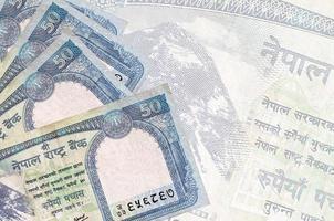 50 nepalese rupie fatture bugie nel pila su sfondo di grande semi trasparente banconota. astratto attività commerciale sfondo foto
