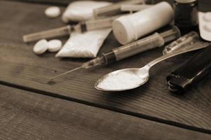 un' lotto di narcotico sostanze e dispositivi per il preparazione di farmaci menzogna su un vecchio di legno tavolo foto