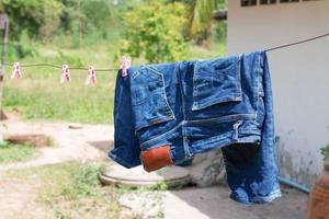 pantaloncini blu jeans sospeso per essiccazione nel sunlingt foto