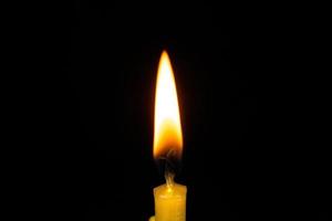 candela fiamma vicino su nero sfondo foto