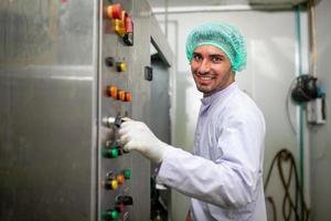 lavoratore è controllo operativo macchina e girare su interruttore su il produzione linea nel il bevanda fabbrica. foto