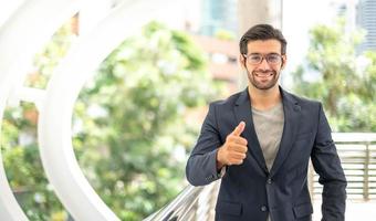 il ritratto di contento giovane bello caucasico uomo d'affari con occhiali e indossare in profondità blu tute per professionale Guarda. foto