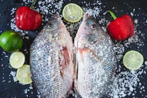 pesce tilapia fresco con sale e condimento foto