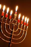 brillantemente raggiante hanukkah candele nel un' stella di david menorah foto