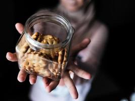 avvicinamento Visualizza di un' donna Tenere un' bicchiere vaso di biscotti foto