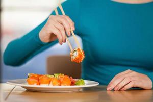 mangiare Sushi. avvicinamento di donna mangiare Sushi a il ristorante foto
