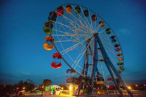 un' attrazione Ferris ruota nel il divertimento parco a notte foto