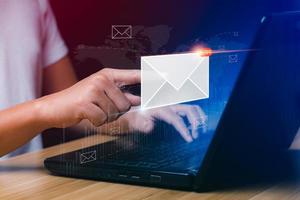 e-mail marketing concetto. uomo d'affari utilizzando tavoletta fare surf Internet su scrivania con e-mail icona, elettronico posta, commercio elettronico. notiziario e-mail e proteggere il tuo personale informazione a partire dal spam posta concetto foto