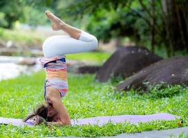 giovane donna yoga all'aperto su il prato. foto