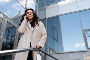 ritratto di un' riuscito giovane esecutivo donna al di fuori un' moderno ufficio costruzione, donna capo nel attività commerciale concetto foto