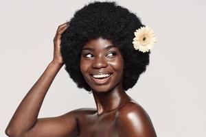 ritratto di bellissimo giovane africano donna toccante capelli e sorridente foto
