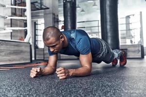 ogni giorno routine. bello giovane africano uomo nel sport capi di abbigliamento tavolato mentre esercizio nel il Palestra foto