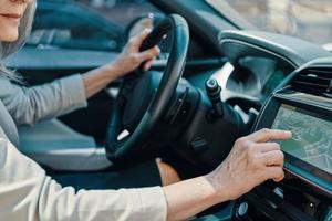 vicino su di donna utilizzando globale posizionamento sistema mentre guida auto foto