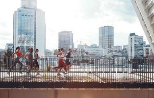 pieno lunghezza di giovane persone nel gli sport capi di abbigliamento jogging mentre esercizio su il ponte all'aperto foto