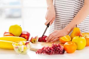 fabbricazione un' frutta insalata. ritagliata Immagine di incinta donna fabbricazione un' frutta insalata foto